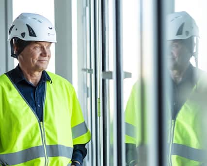 Person in protective wear looking out through a window,
