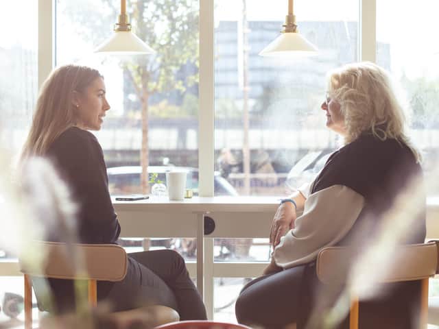 Two people sitting by a window table.